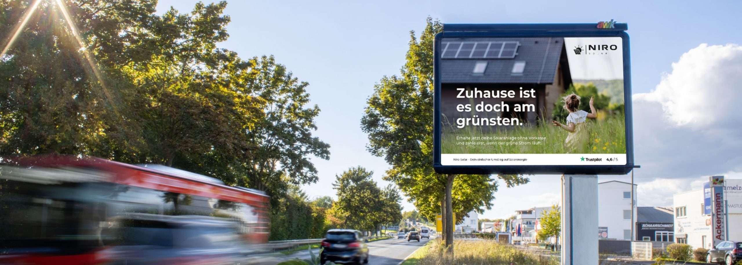 Eine Straße mit einer Werbetafel an der Seite, die Werbung von Niro Solar GmbH zeigt.