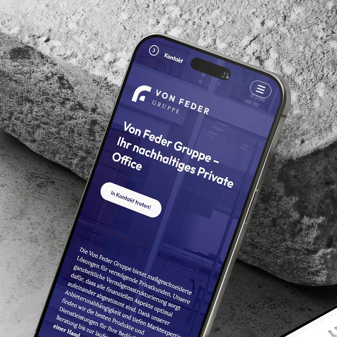 Handy auf Steingrund zeigt das Webdesign der von Feder Gruppe